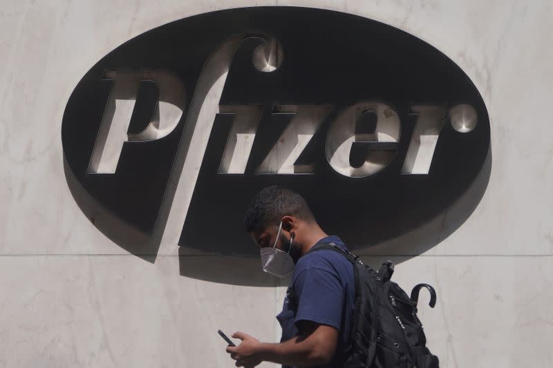 FILE PHOTO: A man walks past a sign outside Pfizer Headquarters in the Manhattan borough of New York City