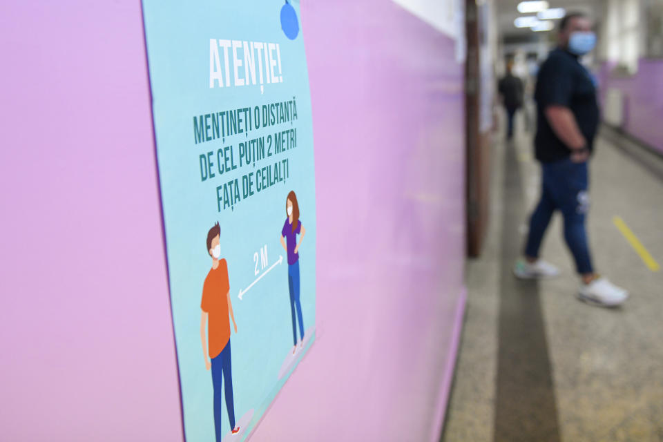 Safety regulations to limit the COVID-19 infection are displayed on the wall of a voting station in Bucharest, Romania, Sunday, Sept. 27, 2020. Some 19 million registered voters are choosing local officials, council presidents and mayors to fill more than 43,000 positions across the European Union nation. (AP Photo/Andreea Alexandru)