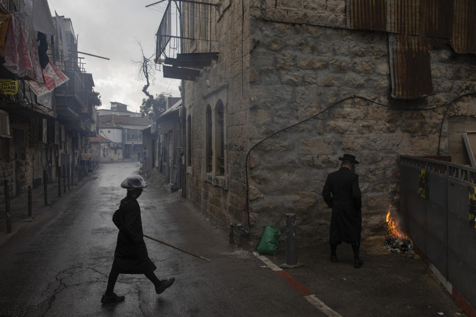 Ultra-Orthodox Jewish man burns leavened items in final preparation for the Passover holiday in Jerusalem, Friday, March 26, 2021. Israelis will once again hold large family gatherings this weekend to celebrate Passover, the festive Jewish holiday recalling the biblical flight of the Israelites from Egypt. That's thanks to a highly successful coronavirus vaccination campaign that has inoculated 80% of the country's adult population. (AP Photo/Oded Balilty)