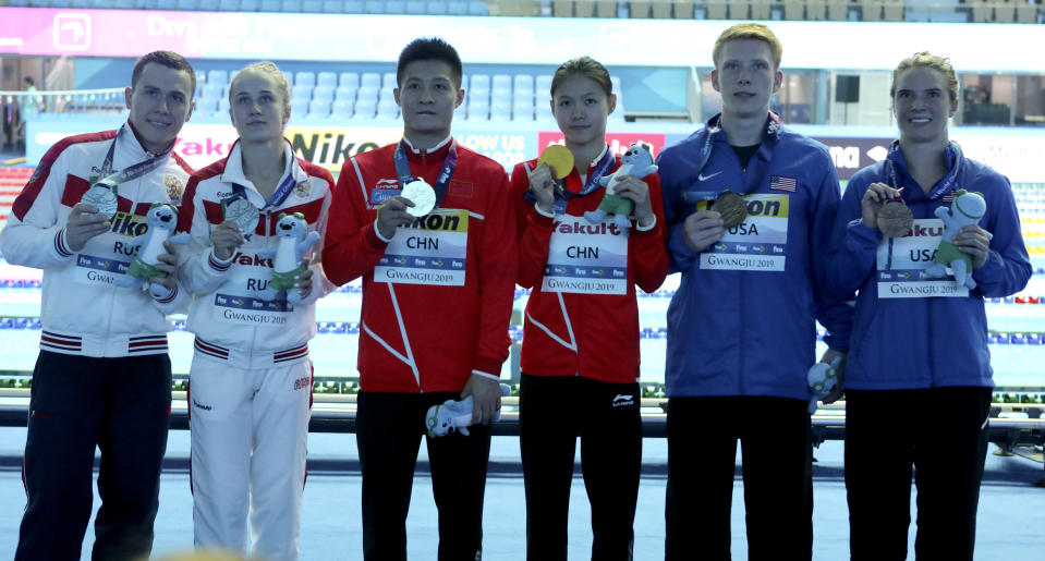 Gold medalists China's Lin Shan and Yang Jian stand with silver medalists Russia's Sergey Nazin and Iuliia Timoshinina and bronze medalists United States' Katrina Young and Andrew Capobianco for the mixed team event diving final at the World Swimming Championships in Gwangju, South Korea, Tuesday, July 16, 2019. (AP Photo/Lee Jin-man )