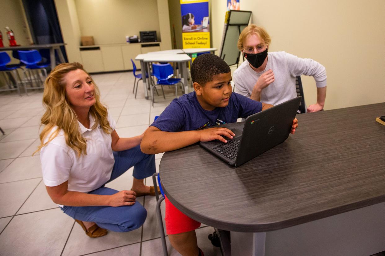 Nikki Tredway, left, and Joey Lewis, right, help 9-year-old Wilson Primary third-grader Thomas Dodson with a tutoring assessment at the My Learning Nook inside the University Park Mall in Mishawaka.