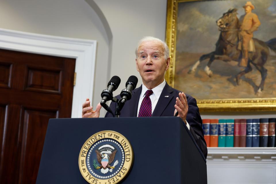 President Joe Biden speaking behind a podium with microphones.