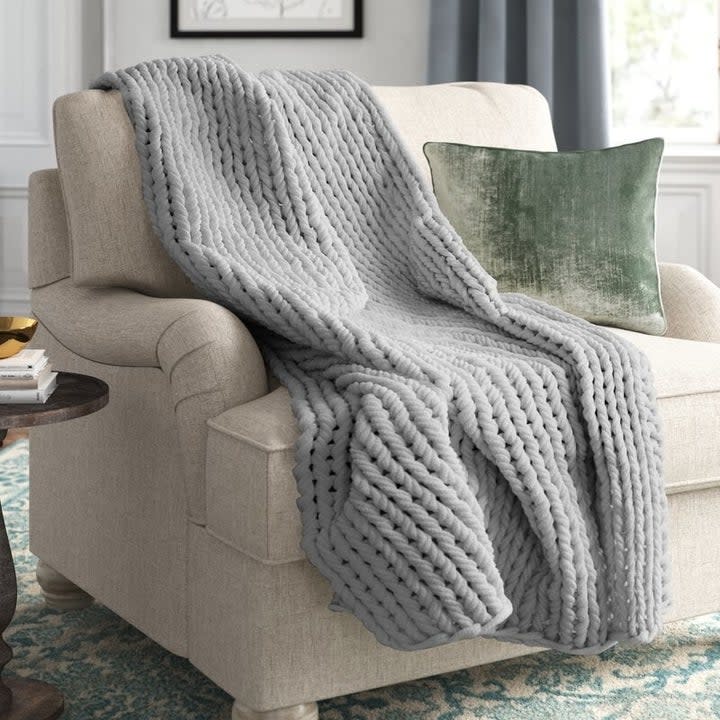 grey knitted blanket on a chair