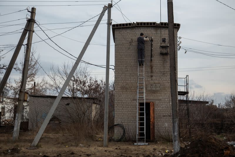 Man repairs power lines in the village of Bilokuzmynivka, Donetsk region