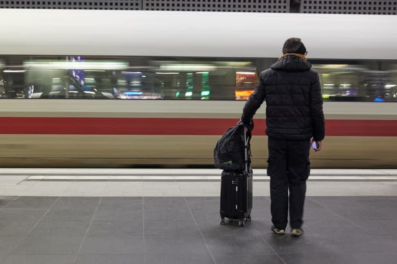 A passenger stands in front of an arriving train at the main station. The German Train Drivers' Union (GDL) has called for the first multi-day strike in the current wage dispute with Deutsche Bahn and other companies from the middle of the week. Joerg Carstensen/dpa