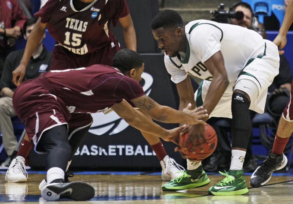 Texas Southern guard Madarious Gibbs, left, and Cal Poly guard Dave Nwaba chase a loose ball in the first half of a first-round game of the NCAA college basketball tournament on Wednesday, March 19, 2014, in Dayton, Ohio. (AP Photo/Skip Peterson)