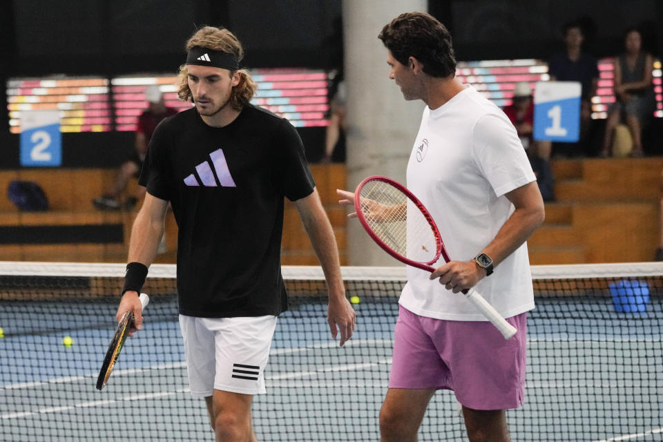 Stefanos Tsitsipas, left, of Greece talks with one of his coaches Mark Philippoussis during a practice session ahead of the men's final at the Australian Open tennis championship in Melbourne, Australia, Saturday, Jan. 28, 2023. Tsitsipas will play Novak Djokovic of Serbia in the final here Sunday Jan. 29.(AP Photo/Dita Alangkara)