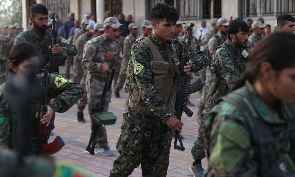 Fighters from the Syrian Democratic Forces attend the funeral of four fellow fighters in Qamishli.