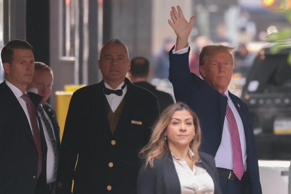 Donald Trump waves to people looking on as he leave Trump Tower on 19 April (AP)