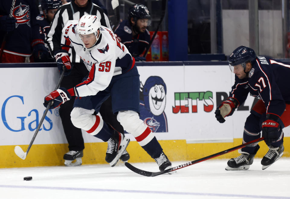 Washington Capitals forward Aliaksei Protas, left, controls the puck in front of Columbus Blue Jackets forward Justin Danforth during the first period a preseason NHL hockey game in Columbus, Ohio, Saturday, Oct. 1, 2022. (AP Photo/Paul Vernon)