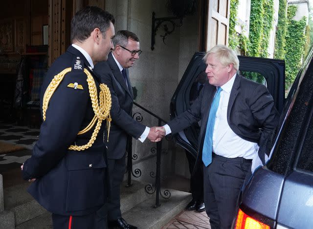 <p>ANDREW MILLIGAN/POOL/AFP via Getty</p> Outgoing Prime Minister Boris Johnson is greeted by the Queen Elizabeth II's Equerry Lieutenant Colonel Tom White and her private Secretary Sir Edward Young as he arrives at Balmoral for an audience to formally resign as Prime Minister on Sept. 6, 2022