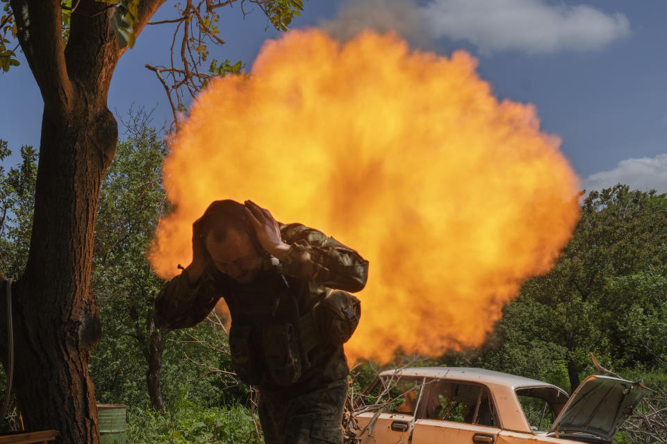 A Ukrainian soldier covers his ears while firing a mortar at Russian positions on the frontline near Bakhmut, Donetsk region, Ukraine, Monday, May 29, 2023. (AP Photo/Efrem Lukatsky)