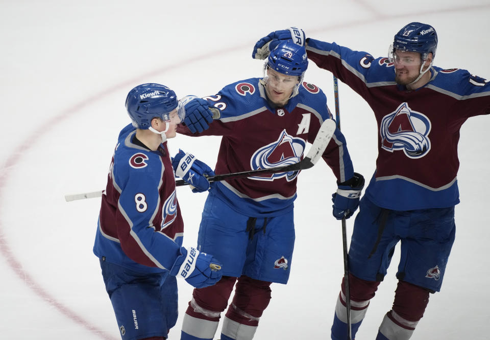 Colorado Avalanche center Nathan MacKinnon, center, who scored in overtime against the New York Islanders, is congratulated by defenseman Cale Makar, left, and right wing Valeri Nichushkin in an NHL hockey gam Tuesday, Jan. 2, 2024, in Denver. (AP Photo/David Zalubowski)