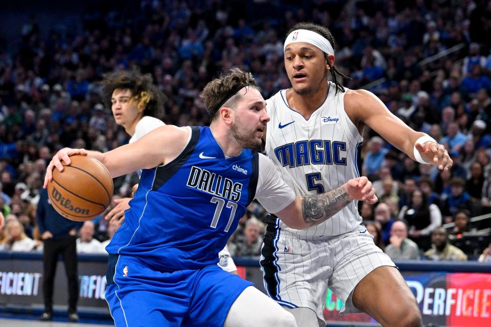 Luka Doncic (77) drives to the basket past the Orlando Magic's Paolo Banchero.