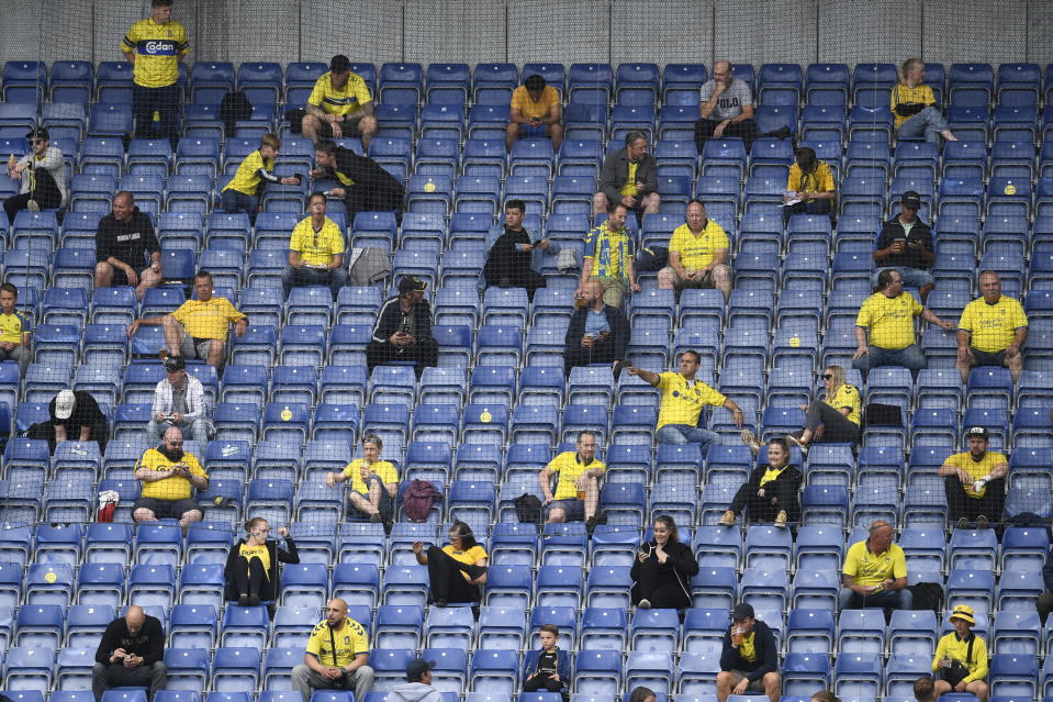 Spectators watch the Danish Supeliga football match Broendby IF and FC Copenhagen, at Broendby Stadium in Broendby, Denmark, Sunday June 21, 2020. The match is one of three selected by Danish authorities to allowed in 3000 spectators, as an attempt to bring more fans into matches after the repeal of the lock down to prevent the spread of the coronavirus. (Lars Moeller/Ritzau Scanpix via AP)