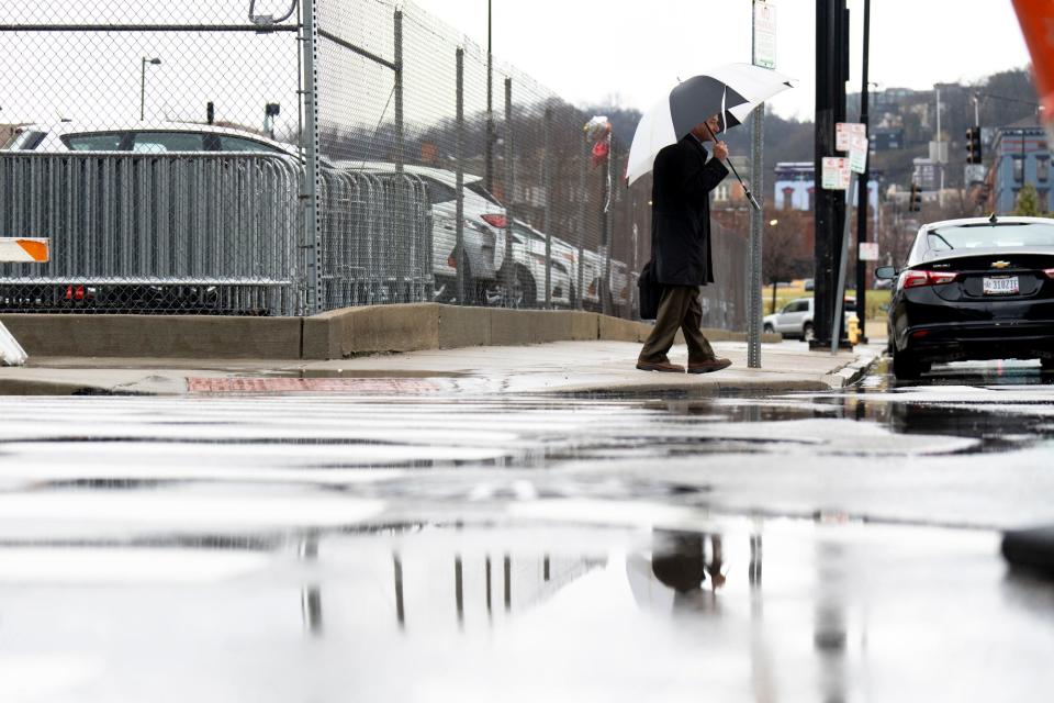 A pedestrian holds an umbrella while walking during a rain storm in Cincinnati on Friday, March 3, 2023. 