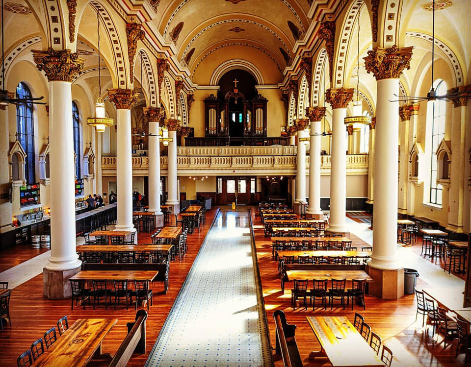 This photo provided by Jon Holley shows the Ministry of Brewing, housed in what was once St. Michael the Archangel Church in Baltimore. The church reopened to the public as a brewery in January 2020, featuring a dazzling interior with soaring columns and a mural-painted barrel ceiling. The brewery also hosts events, fundraisers and even local delegate debates. (Courtesy of Ministry of Brewing via AP)