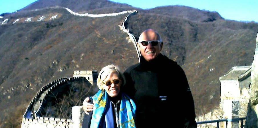 Roxana and Fred Seely pose in front of the Great Wall of China.