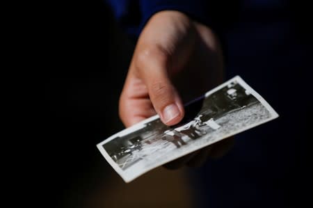 A student volunteer holds a pictute as she cleans debris from an elders' home, in the aftermath of Typhoon Hagibis in Yanagawamachi district, Date City