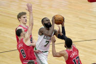 Boston Celtics guard Jaylen Brown (7) shoots between Chicago Bulls' Zach LaVine (8) Garrett Temple (17) and Lauri Markkanen during the first half of an NBA basketball game Monday, Jan. 25, 2021, in Chicago. (AP Photo/Charles Rex Arbogast)