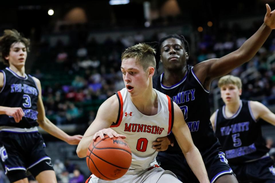 Munising guard Kane Nebel (0) dribbles against  Wyoming Tri-unity Christian forward Akais Giplaye (20) during the second half of the MHSAA boys Division 4 final at Breslin Center in East Lansing on Saturday, March 25, 2023.