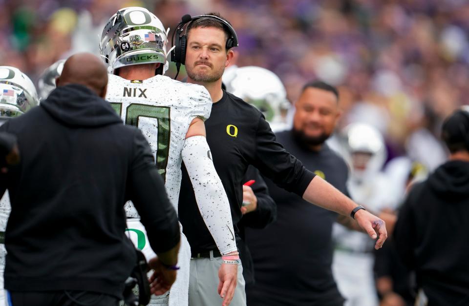 Oregon quarterback Bo Nix is greeted by head coach Dan Lanning during the first half of the game against Washington Oct. 14 in Seattle.