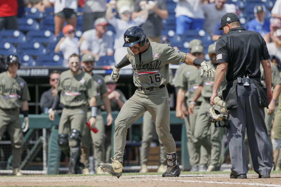 Vanderbilt's Austin Martin (16) stomps on home plate after hitting a two-run home run against Louisville in the seventh inning of an NCAA College World Series baseball game in Omaha, Neb., Sunday, June 16, 2019. (AP Photo/Nati Harnik)
