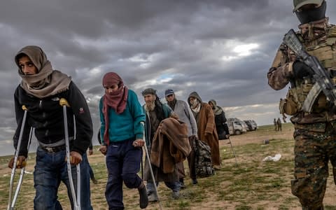 Men suspected of being Isil fighters wait to be searched by members of the Kurdish-led Syrian Democratic Forces (SDF) - Credit: AFP