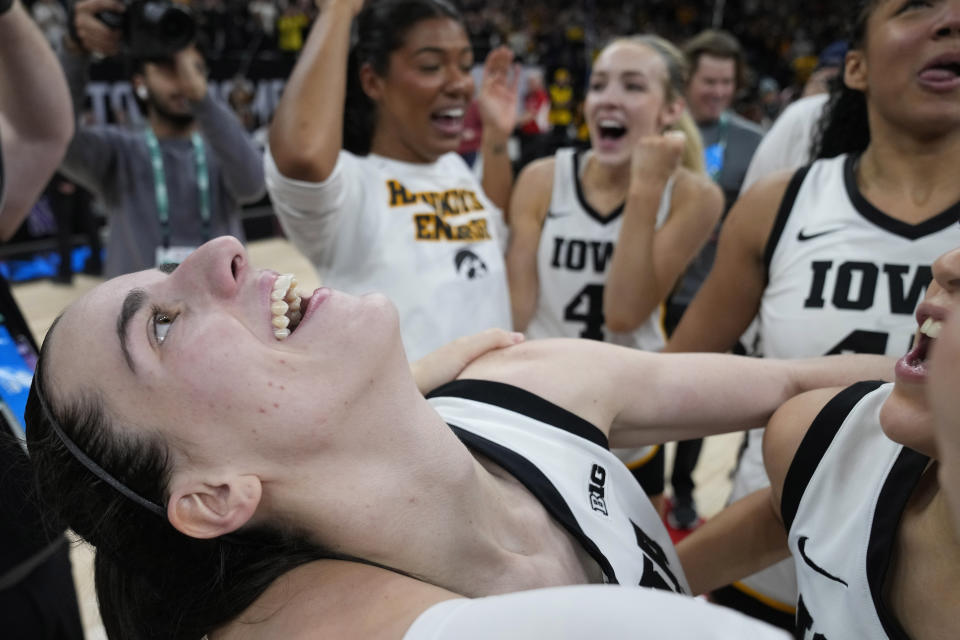 Iowa guard Caitlin Clark, left, celebrates with teammates after the overtime win against Nebraska of NCAA college basketball game in the final of the Big Ten women's tournament Sunday, March 10, 2024, in Minneapolis. (AP Photo/Abbie Parr)