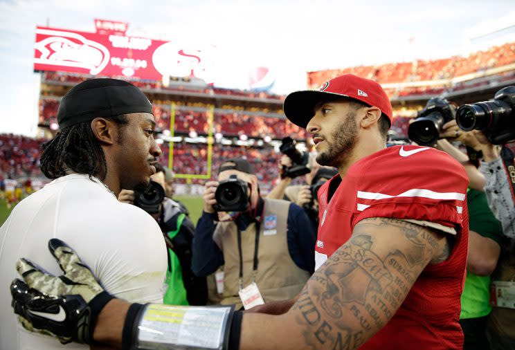 Robert Griffin III, Colin Kaepernick in happier, more employed days. (Getty Images)