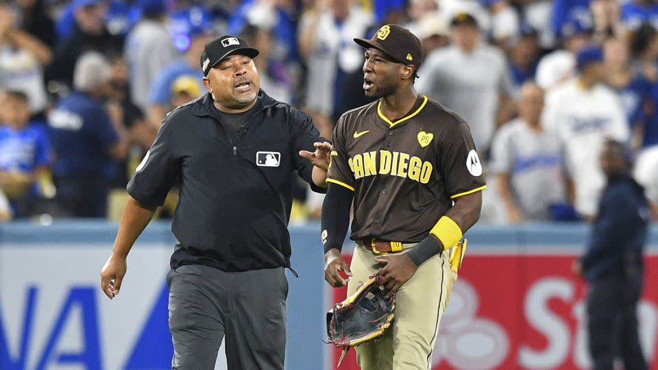 Padres outfielder Jurickson Profar speaks with an umpire during a delay due to fans throwing items on the field. - Brian Rothmuller/Icon Sportswire/AP