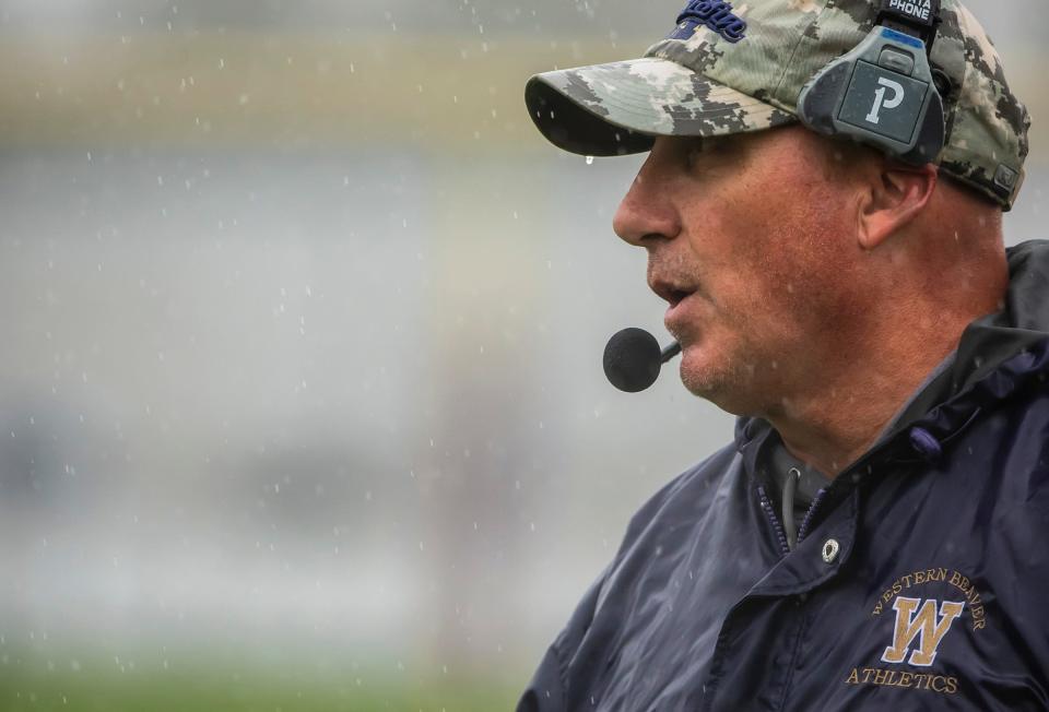 Heavy rain falls on Western Beaver head coach Ron Busby during their game against Freedom Saturday at Western Beaver High School. [Lucy Schaly/For BCT]