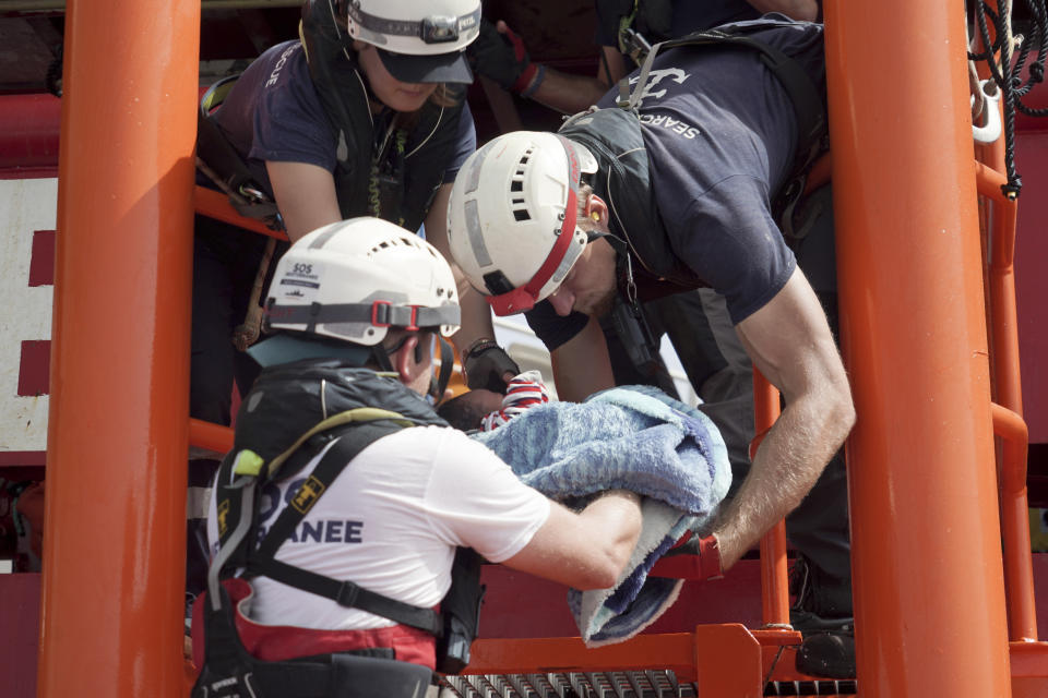 A newborn baby is carried onto the Ocean Viking humanitarian rescue ship after a rescue operation some 53 nautical miles (98 kilometers) from the coast of Libya in the Mediterranean Sea, Tuesday, Sept. 17, 2019. The humanitarian rescue ship Ocean Viking pulled 48 people from a small and overcrowded wooden boat including a newborn and a pregnant woman. (AP Photo/Renata Brito)