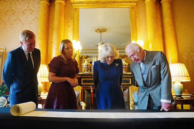 <p>Victoria Jones - WPA Pool/Getty</p> Queen Camilla and King Charles are presented with the coronation roll at Buckingham Palace on May 1, 2024