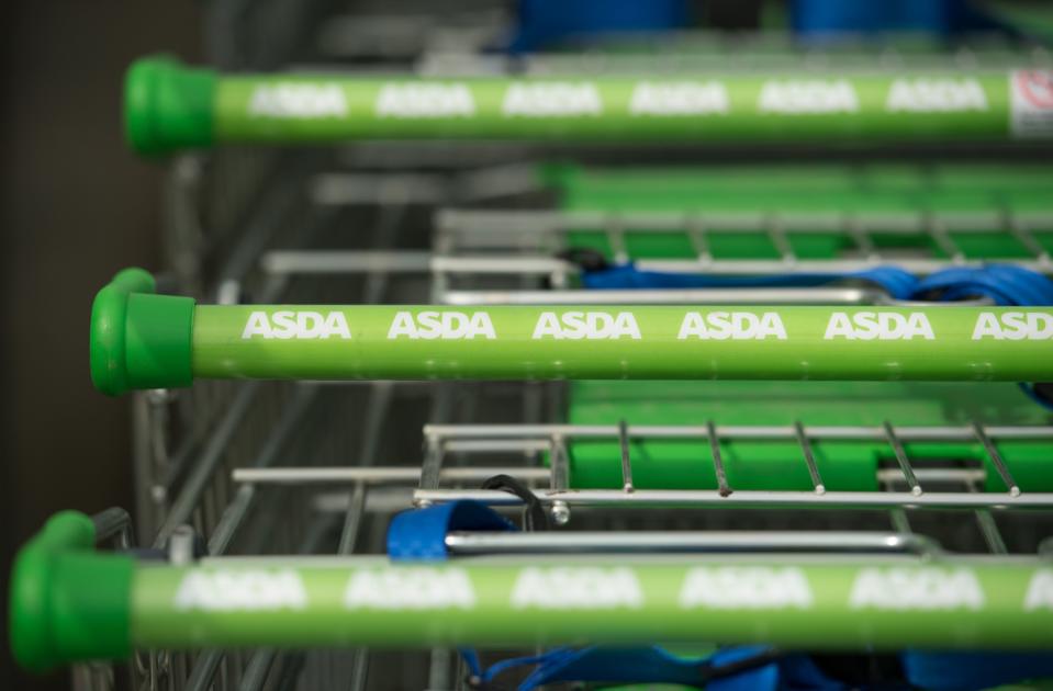 Logos of supermarket chain Asda are pictured on the handles of shopping trolleys outside a store in Stockport, northern England on April 30, 2018. - Britain's second and third biggest supermarket chains Sainsbury's and Walmart-owned Asda have agreed to merge, the pair said Monday, hoping to create a £13-billion ($18-billion, 15-billion-euro) retail king and leapfrog UK number one Tesco. The blockbuster deal -- which is effectively a takeover bid with Sainsbury's acquiring a majority 58-percent stake -- comes as the British supermarket sector faces squeezed profit margins and fierce competition from German-owned discounters Aldi and Lidl and online US titan Amazon. (Photo by Oli SCARFF / AFP)        (Photo credit should read OLI SCARFF/AFP via Getty Images)