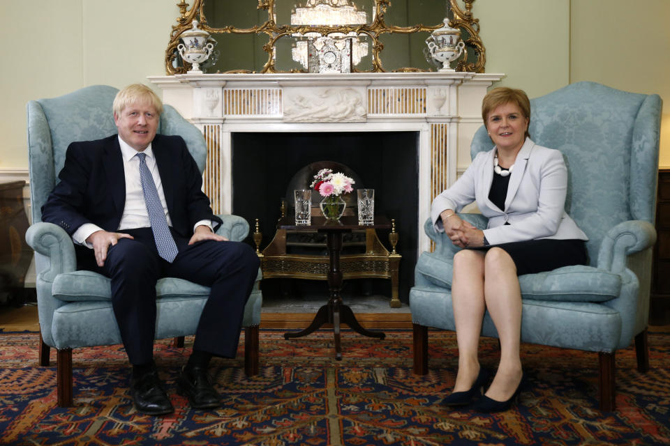 Scotland's First Minister Nicola Sturgeon, right, sits with Britain's Prime Minister Boris Johnson, in Bute House, ahead of their meeting, in Edinburgh, Scotland, Monday July 29, 2019. Johnson made his first official visit as British prime minister to Scotland, pledging to boost "the ties that bind our United Kingdom" amid opposition from Scottish leaders to his insistence on pulling Britain out of the European Union with or without a deal. (Duncan McGlynn/Poo Photo via AP)