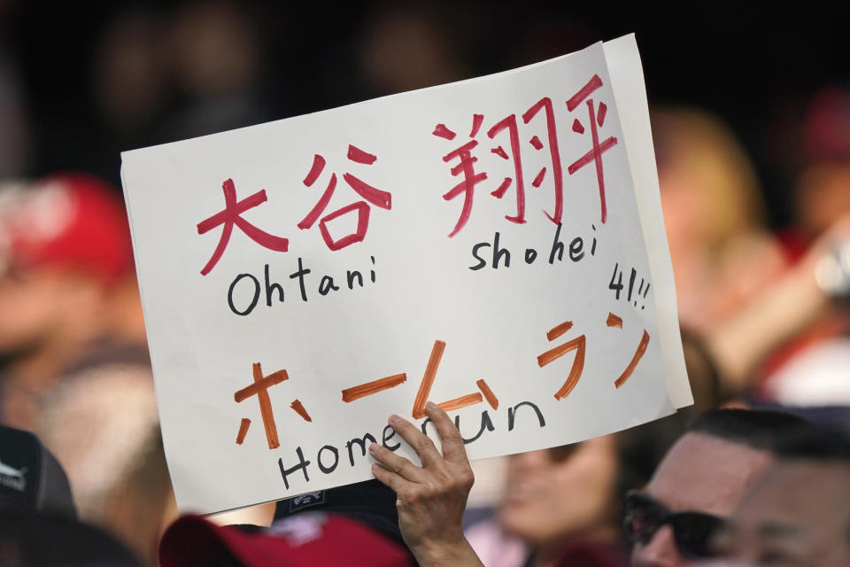 A fan of Los Angeles Angels' Shohei Ohtani holds up a sign during the sixth inning of the Angels' baseball game against the Cleveland Indians, Saturday, Aug. 21, 2021, in Cleveland. (AP Photo/Tony Dejak)