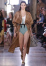 <p>Kendall makes the flasher look chic in a swimsuit and trenchcoat at Bottega Veneta. </p>