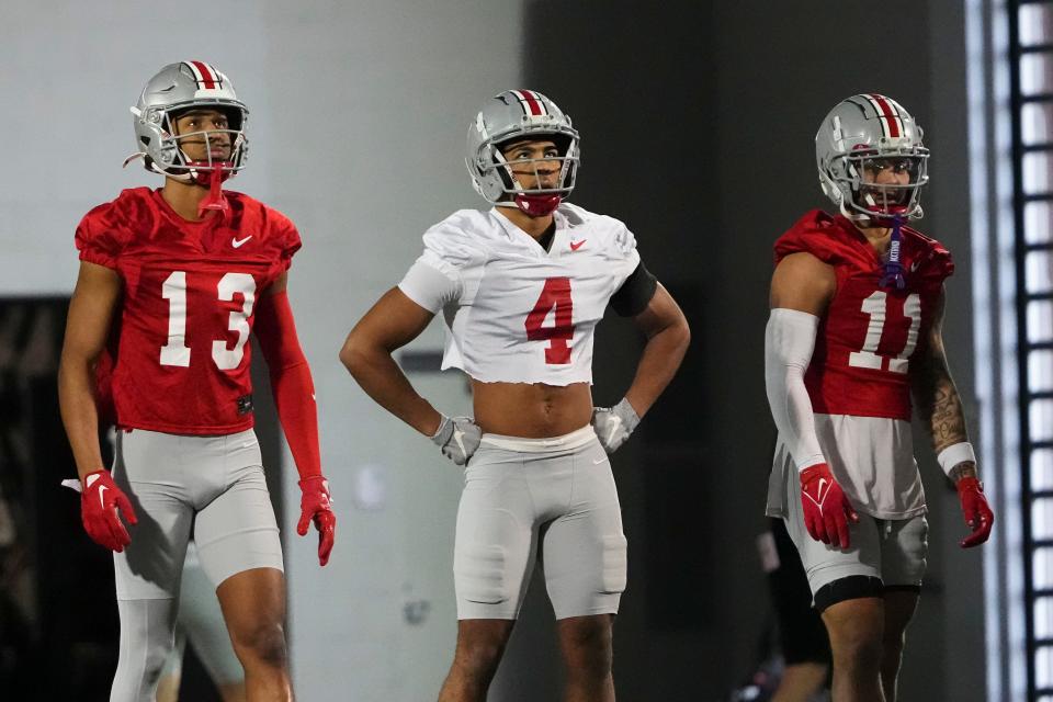 March 7, 2024;  Columbus, Ohio, USA;  Ohio State Buckeyes wide receiver Bryson Rodgers (13), cornerback Lorenzo Styles Jr. (4) and wide receiver Brandon Inniss (11) wait to take turns returning punts during spring football practice at Woody Hayes Athletic Center.