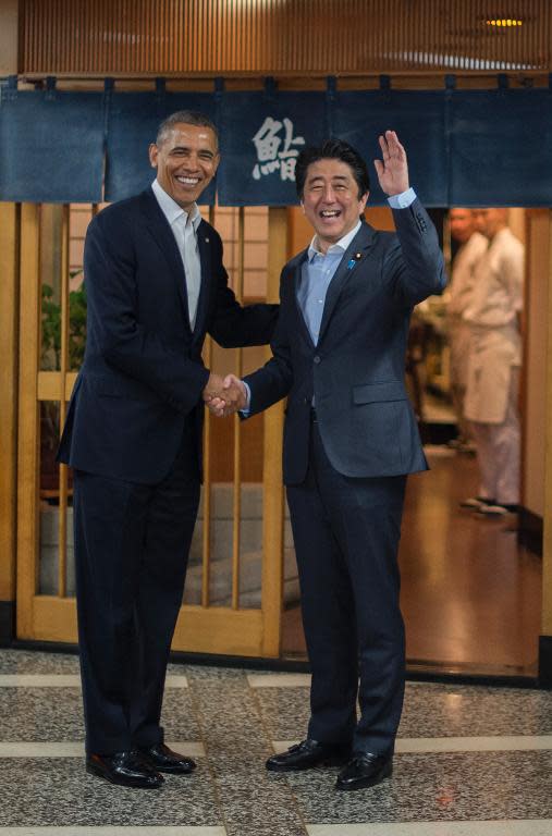 US President Barack Obama (L) shakes hands with Japanese Prime Minister Shinzo Abe before a private dinner at Sukiyabashi Jiro restaurant in Tokyo on April 23, 2014