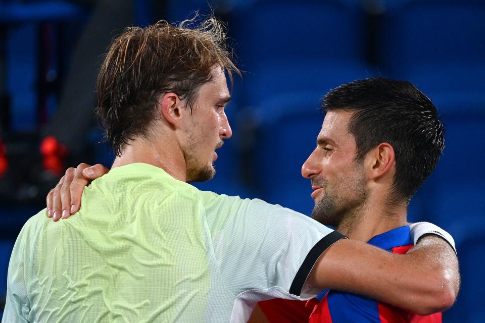 Serbia's Novak Djokovic (R) congratulates Germany's Alexander Zverev for winning their Tokyo 2020 Olympic Games men's singles semifinal tennis match at the Ariake Tennis Park in Tokyo on July 30, 2021. (Photo by Vincenzo PINTO / AFP) (Photo by VINCENZO PINTO/AFP via Getty Images)