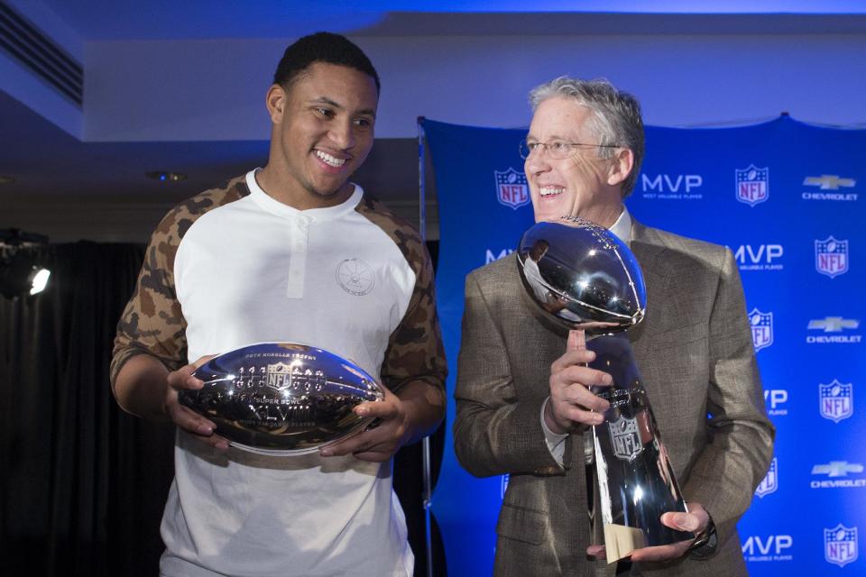 Seattle Seahawks head coach Pete Carroll, right, poses for a photograph with the Vince Lombardi trophy alongside Super Bowl XLVIII MVP Malcolm Smith, during a news conference at the Super Bowl Media Center at the Sheraton hotel, Monday, Feb. 3, 2014, in New York. The Seattle Seahawks defeated the Denver Broncos, 43-8. (AP Photo/John Minchillo)