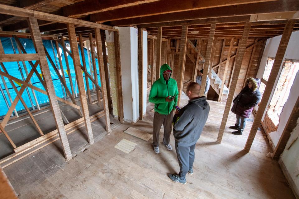 From the left, Co-founder Anthony Moore talks with Cody Lighty, vice president of Four Square Construction, while future resident of one of the homes, Tamra Langle, looks on.