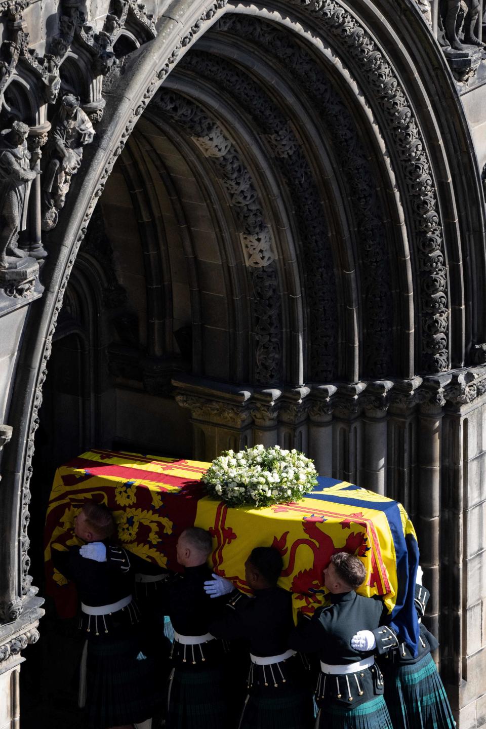 Pallbearers carry the coffin of Queen Elizabeth II, draped in the Royal Standard of Scotland, into St Giles' Cathedral, in Edinburgh, on September 12, 2022, for a service of Thanksgiving for her life.