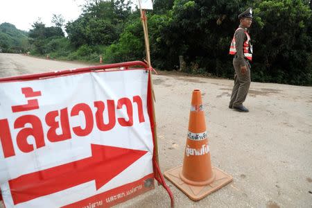 Police officers block a road leading to the Tham Luang cave complex, where members of a soccer team trapped are in a flooded cave, in the northern province of Chiang Rai, Thailand, July 9, 2018. REUTERS/Soe Zeya Tun