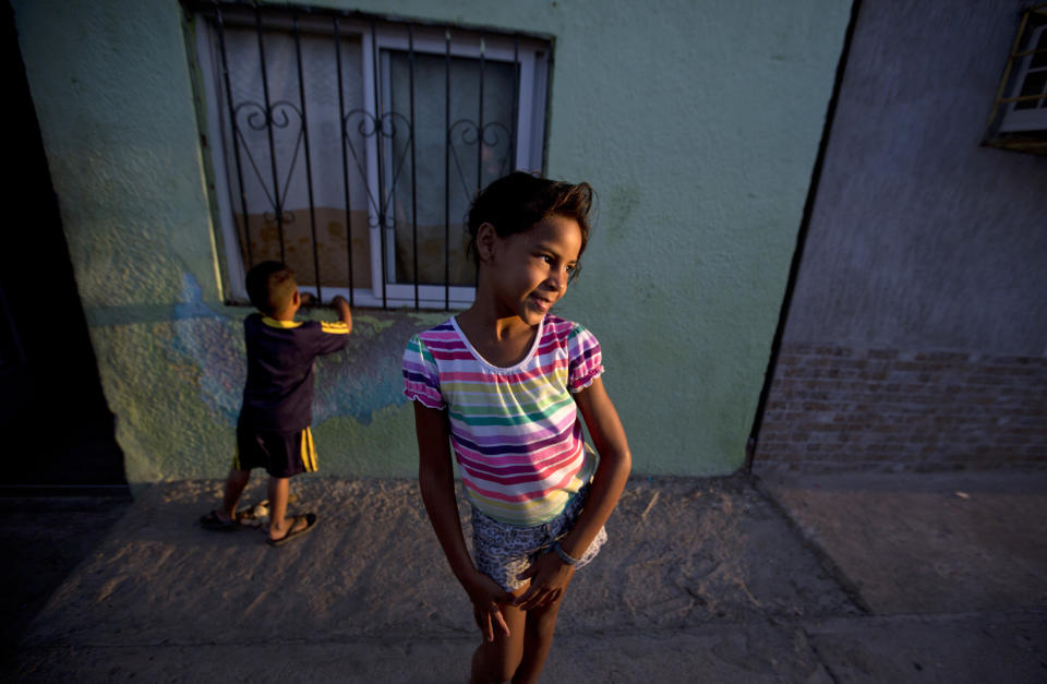 In this Dec. 10, 2018 photo, Solgreidy, 8, and her 3-year-old brother Elvis stand outside of their uncle's home in Punto Fijo, Venezuela. "I told her goodbye," Solgreidy said, crying as she recalled the day six months ago when her mother walked her to school for the last time, before her mother left for Colombia. "And since then I haven't seen her again." (AP Photo/Fernando Llano)