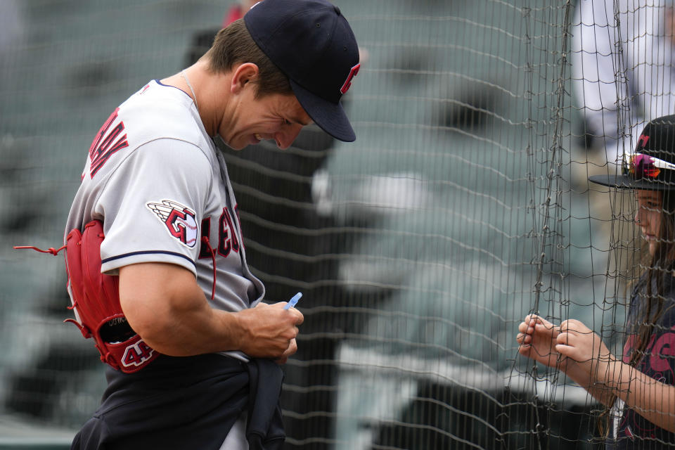 Cleveland Guardians pitcher James Karinchak signs autographs for fans after a baseball game against the Chicago White Sox, Thursday, May 18, 2023, in Chicago. The Guardians won 3-1. (AP Photo/Erin Hooley)
