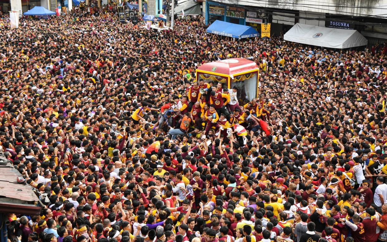 Catholic devotees jostle to touch the glass-covered carriage carrying the so-called Black Nazarene in Manila