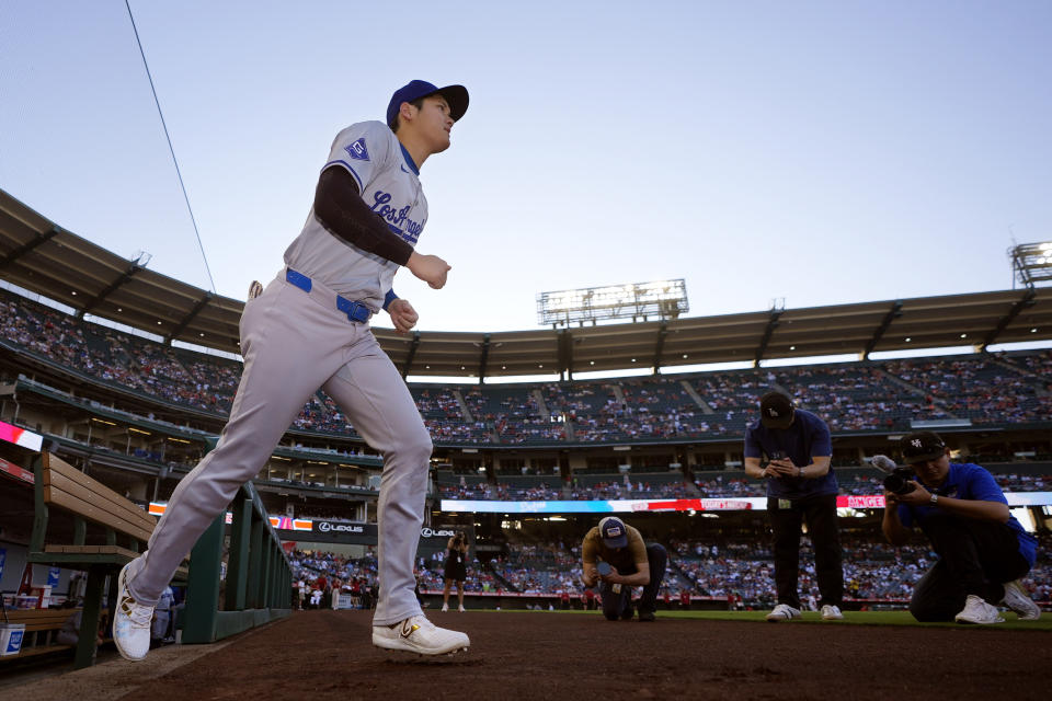 Los Angeles Dodgers' Shohei Ohtani walks out of the dugout to warm up prior to a baseball game against the Los Angeles Angels Tuesday, Sept. 3, 2024, in Anaheim, Calif. (AP Photo/Mark J. Terrill)