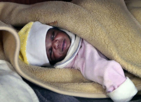 A migrant baby girl is seen sleeping aboard the former fishing trawler Golfo Azzurro, about thirty-two hours after her rescue along other migrants from their drifting plastic rafts by Spanish NGO Proactiva Open Arms, in the Mediterranean Sea, off the Libyan coast April 2, 2017. REUTERS/Yannis Behrakis